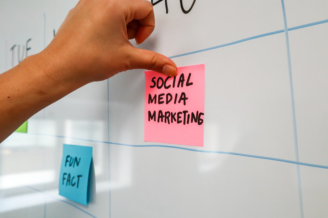 services-02 Person sticking a post-it on a white board with the words Social Media Marketing written on it